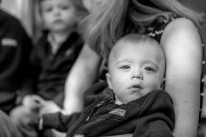 Black and white photo of an infant with another small child in the background