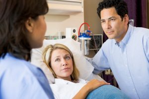 Doctor has serious conversation with pregnant mom and dad over a hospital bed