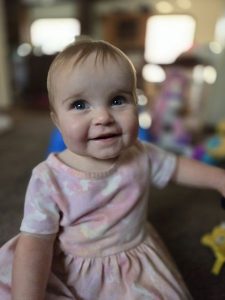 Baby smiles broadly in the comfort of home.  