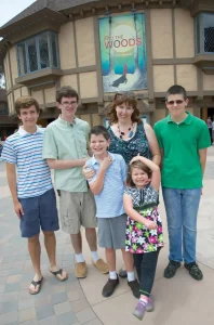 Mother of five stands with her smiling children