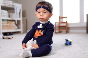 Toddler with CCMS diagnosis plays on the floor.