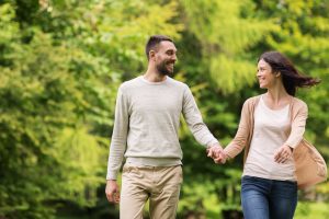 Young couple, walking, holding hands and smiling 