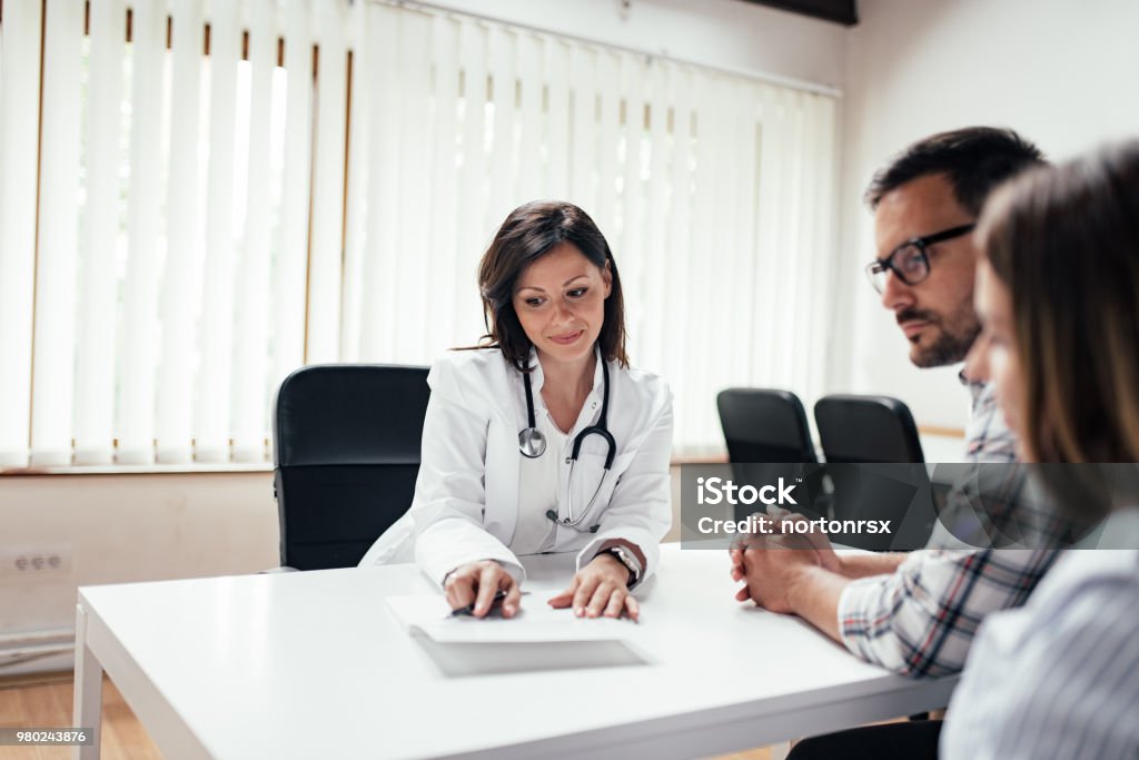 Doctor discussing with couple in the clinic.