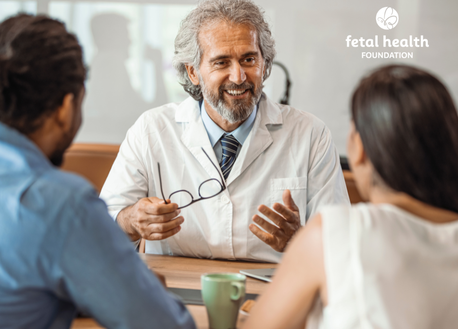 Male doctor discusses care with couple across a desk