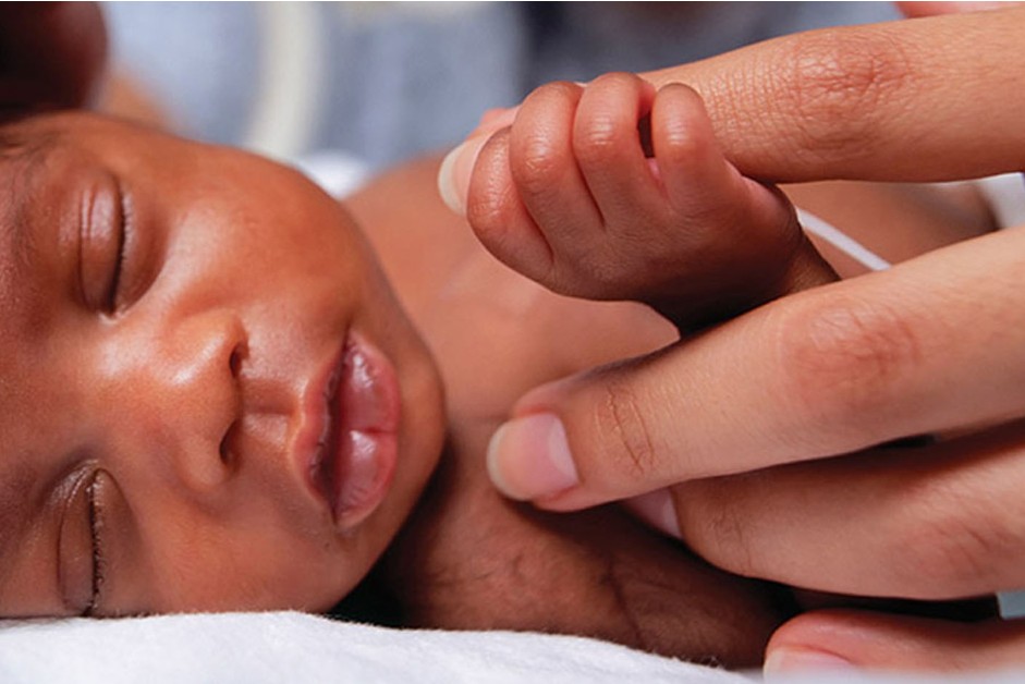 Neonate holds the finger of his caregiver